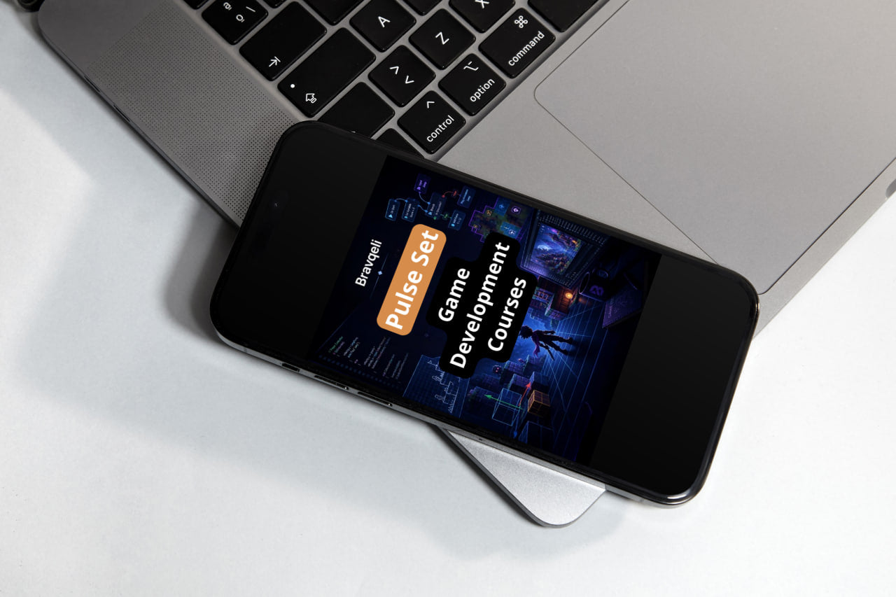 Phone displaying a game development course app on a laptop